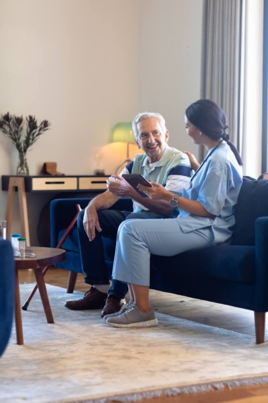 A picture of a therapist engaging in conversation at the patient's home.