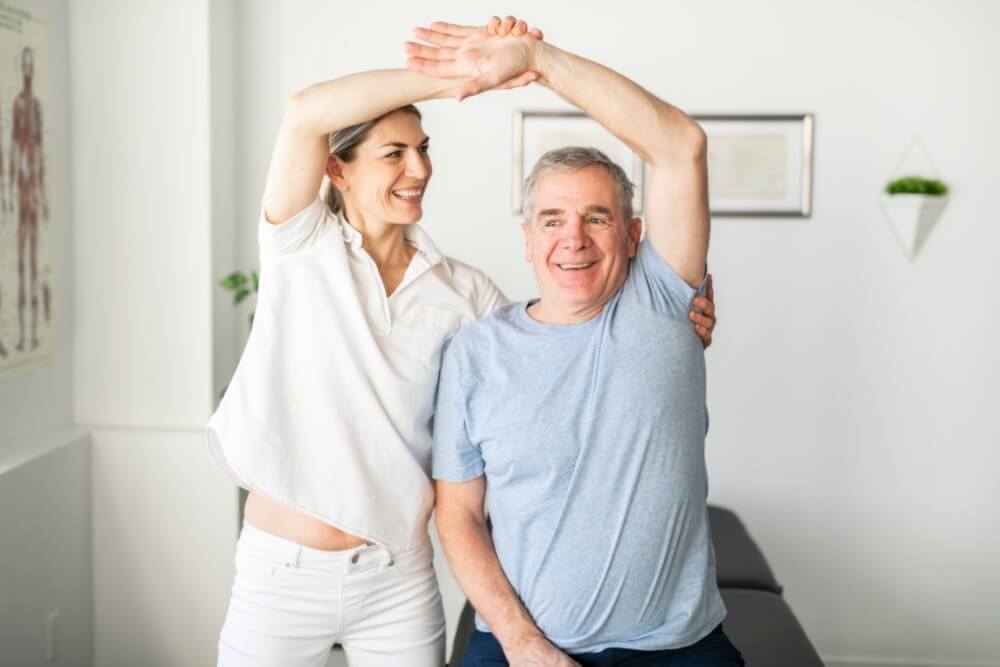 A photo showing a therapist guiding a patient's hand exercise by holding their wrist